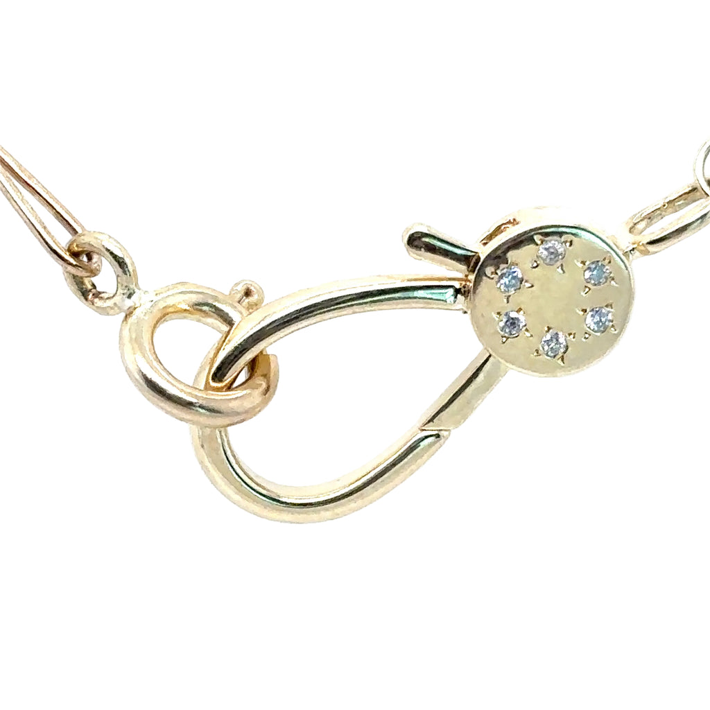 Gold necklace with a diamond clasp on a white background
